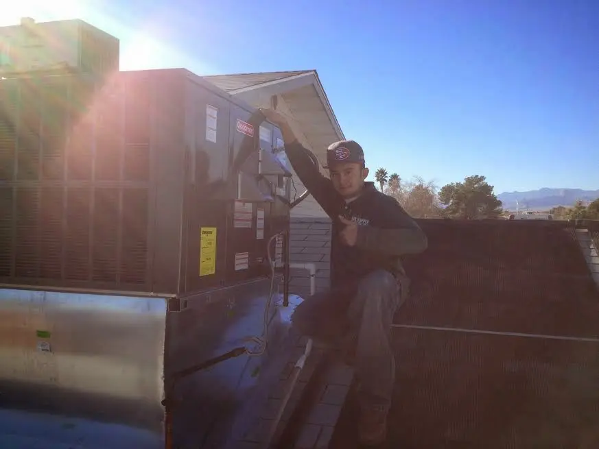 HVAC technician performing Air Duct Repair on a rooftop unit in Ridgeway